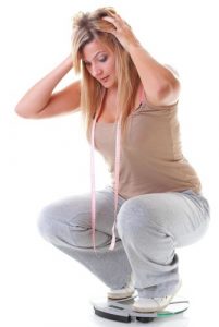 Woman on scale unhappy with weight