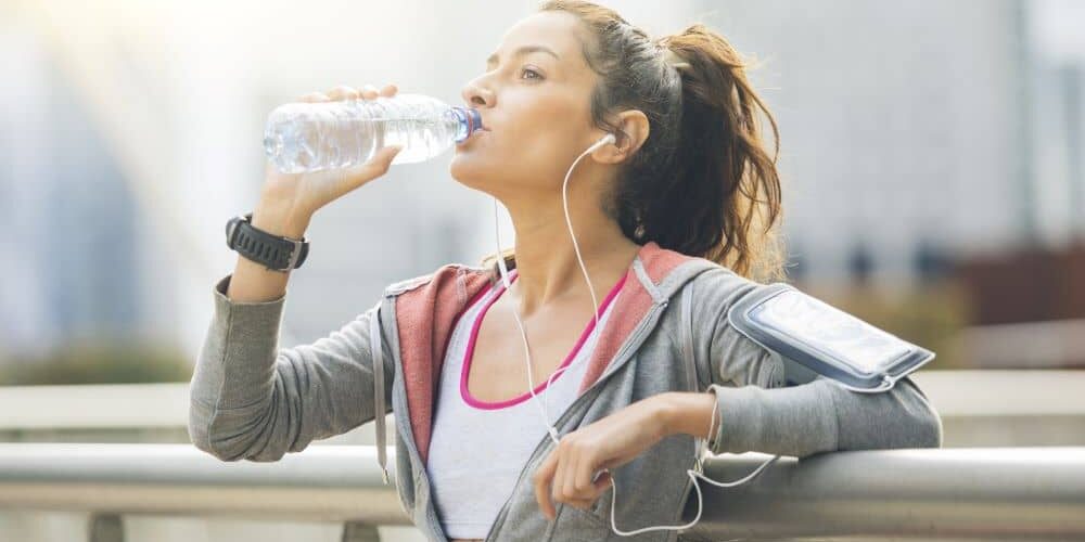 Woman drinking water after jogging. Drinking water is one of the easiest ways to maintain our health.